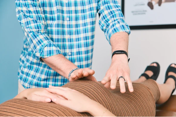 chiropractic osteopathic doctor makes a massage to a pregnant girl.